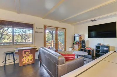 a living room with a couch and a flat screen tv at Family-Friendly Lake Arrowhead Cabin with Game Room! in Lake Arrowhead
