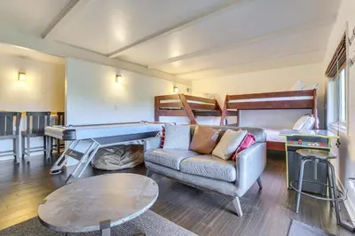 a living room with a couch and a ping pong table at Family-Friendly Lake Arrowhead Cabin with Game Room! in Lake Arrowhead