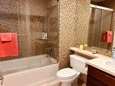 a bathroom with a tub and a toilet and a sink at Cozy private room and bathroom in prime location with rooftop views 30 day stays or more in Los Angeles