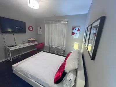 a bedroom with a bed and a desk and a television at Cozy private room and bathroom in prime location with rooftop views 30 day stays or more in Los Angeles