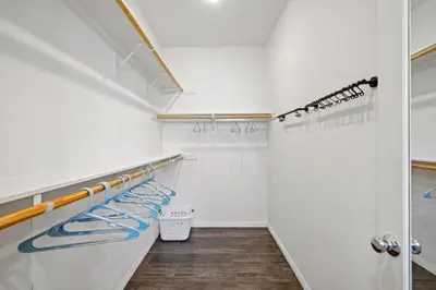 a walk in closet with white walls and wood floors at Gorgeous Family Home, Close to Frwys, Hospitals & Sports Arenas, Pets OK in Orange