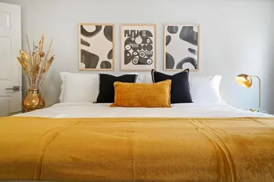 a bedroom with a large bed with a yellow blanket at Foosball l LA Mural l DTLA l UnivStudios l BevHills in Glendale