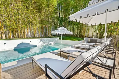 a patio with chairs and a pool with trees at Casa Cortona by Stay Awhile Villas in Los Angeles