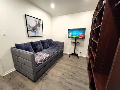 a living room with a couch and a flat screen tv at Perfectly located Pico Robertson ground floor 3 bedroom apartment Walk to restaurants WIFI TV Game Console Parking 5 minutes to Rodeo Drive in Los Angeles