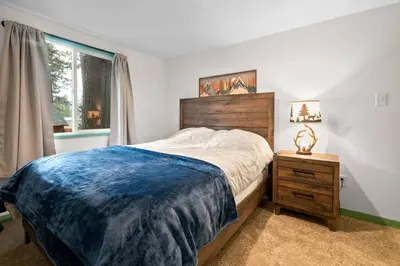 a bedroom with a bed and a nightstand and a window at Midnight Pines Cabin - Cozy Get-Away Near Slopes! in Big Bear Lake