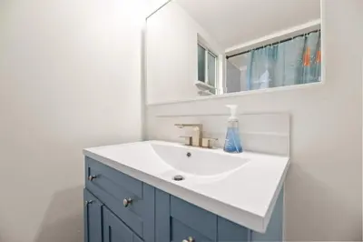 a bathroom with a blue and white sink and a mirror at Midnight Pines Cabin - Cozy Get-Away Near Slopes! in Big Bear Lake
