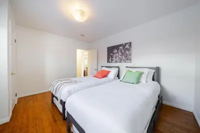 two beds in a room with white walls at Pool Spa Games Peaceful Garden Retreat in Glendale