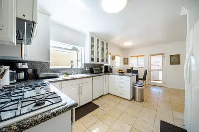 a kitchen with white cabinets and a stove top oven at Pool Spa Games Peaceful Garden Retreat in Glendale
