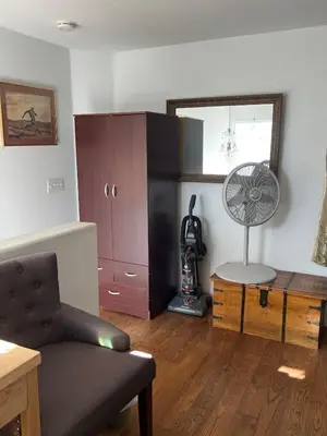 a living room with a chair and a fan at B and G Studio Space Guesthouse in San Bernardino
