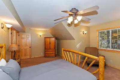 a bedroom with a ceiling fan and a bed at Big 10 Luxury Cabin/Walk to Snow Summit- HotTub in Big Bear Lake