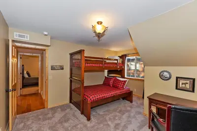 a room with two bunk beds and a desk at Big 10 Luxury Cabin/Walk to Snow Summit- HotTub in Big Bear Lake