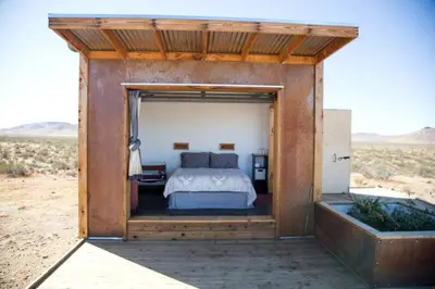a bedroom with a bed in the middle of the desert at Secluded Glamping Eco-Pod Rental in the Mojave Desert near Ridgecrest, California in Ridgecrest
