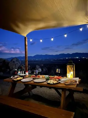 a picnic table with food on it with a view at Stunning Geo Dome with Joshua Tree vibes in Palmdale