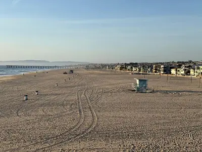 an empty beach with tracks in the sand at Oceanfront 2 BR w Pool & Parking 234 in Hermosa Beach
