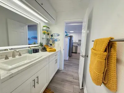 a white bathroom with a sink and a mirror at Oceanfront 2 BR w Pool & Parking 234 in Hermosa Beach