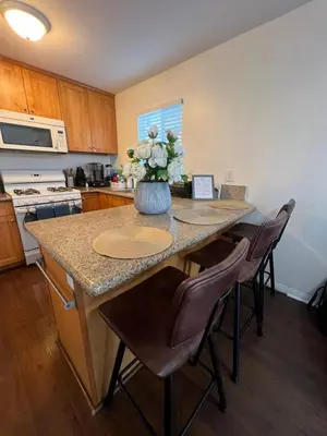 a kitchen with a table with a vase of flowers on it at Mini-Home in Whittier in Whittier
