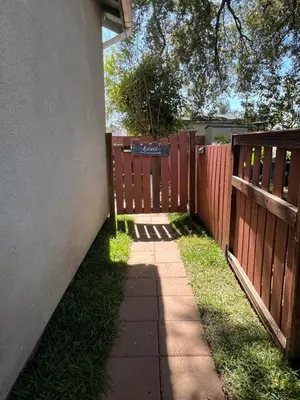 a sidewalk next to a fence with a gate at Mini-Home in Whittier in Whittier