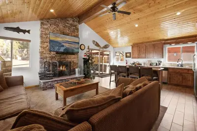 a living room with couches and a kitchen with a fireplace at Lakeside Cottage, Charming 3-BDRM Retreat W Hottub in Big Bear Lake