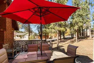 a red umbrella sitting on top of a table at Lakeside Cottage, Charming 3-BDRM Retreat W Hottub in Big Bear Lake
