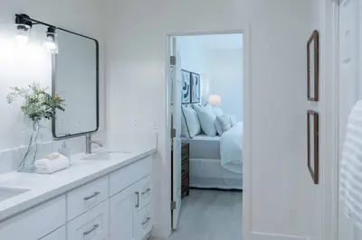 a white bathroom with a sink and a mirror at Newly built vacation home with large backyard in Diamond Bar