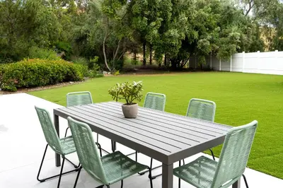 a wooden table with chairs and a potted plant on it at Newly built vacation home with large backyard in Diamond Bar