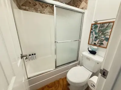 a bathroom with a toilet and a glass shower at Oceanfront Sanctuary 1 BR Beach Access 218 in Hermosa Beach