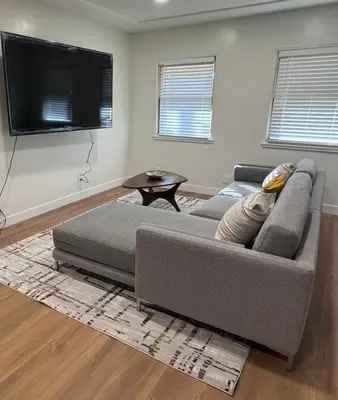 a living room with a couch and a flat screen tv at Modern Bedroom in Long Beach 1 in Long Beach