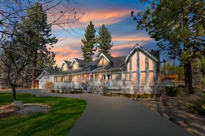 an exterior view of a large white house with a driveway at Lakefront Estate with Views and Hot tub in Big Bear Lake