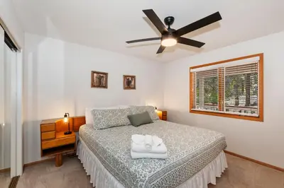 a bedroom with a bed with a ceiling fan at Lakefront Estate with Views and Hot tub in Big Bear Lake
