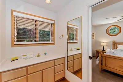 a bathroom with a tub and a sink and a mirror at Lakefront Estate with Views and Hot tub in Big Bear Lake