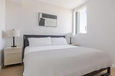 a white bedroom with a white bed and two lamps at Blueground Downtown elevator nr parks LAX-1250 in Los Angeles