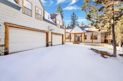a house with a garage in the snow at Castlewood Retreat at Big Bear Central Modern Family Chalet in Big Bear Lake