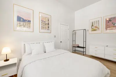 a white bedroom with a white bed and some pictures at Castlewood Retreat at Big Bear Central Modern Family Chalet in Big Bear Lake