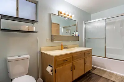 a bathroom with a toilet and a sink and a mirror at Cozy 2BR Retreat Near Lake Grego with Mountain Views in Crestline