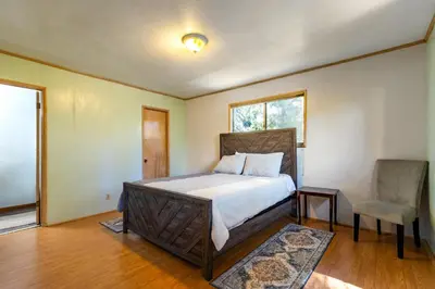 a bedroom with a bed and a chair in it at Cozy 2BR Retreat Near Lake Grego with Mountain Views in Crestline