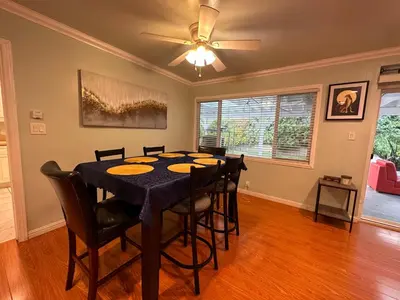 a dining room with a table with chairs and a ceiling fan at Suburban oasis home in Monterey Park