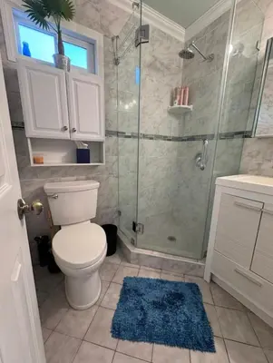 a bathroom with a toilet and a glass shower at Suburban oasis home in Monterey Park