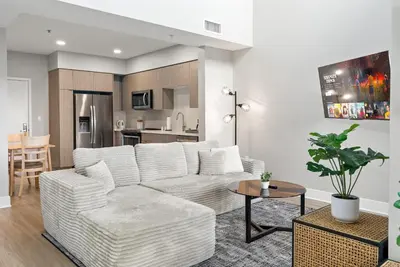a living room with a white couch and a table at Spacious Loft- Hollywood Free Pool, Parking, Gym in Los Angeles