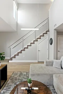a living room with a couch and a staircase at Spacious Loft- Hollywood Free Pool, Parking, Gym in Los Angeles