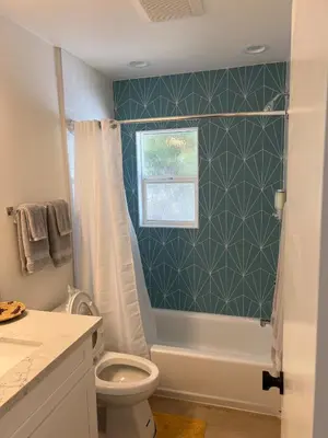 a bathroom with a shower and a toilet and a window at Private guest cottage in Long Beach