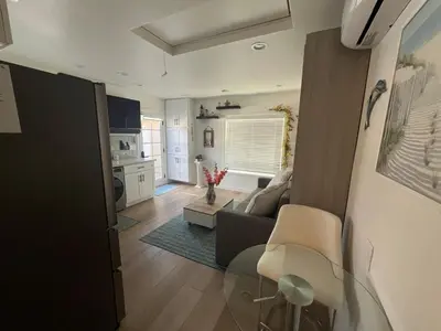 a living room with a couch and a table at Private guest cottage in Long Beach