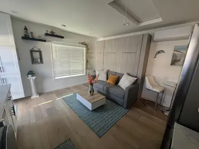 a living room with a couch and a table at Private guest cottage in Long Beach