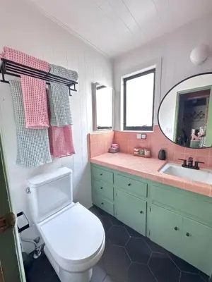 a bathroom with a toilet and a sink and a mirror at A-Frame with Carousel Fireplace in Running Springs