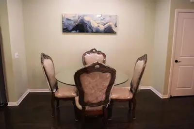 a dining room with a table and chairs and a painting at Pretty Relaxed Me in Brea