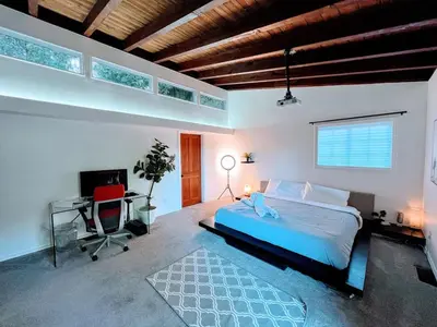 a bedroom with a bed and a desk and a computer at Tranquil and Secluded Retreat in Topanga Canyon in Topanga