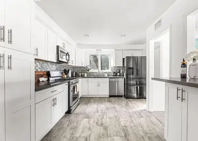 a kitchen with white cabinets and stainless steel appliances at Love & LuxuryHeart Shaped Pool Paradise in Los Angeles