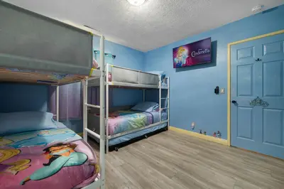 a bedroom with two bunk beds and a tv at Princess Palace by OC Adventure Homes in Anaheim