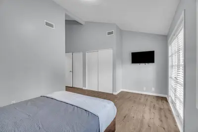 a white bedroom with a bed and a flat screen tv at Sunny Simi Valley Valley 4BR 3BR LTR Modern Home Dedicated Work Place High Speed internet in Simi Valley