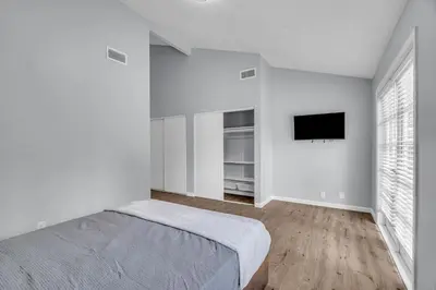 a white bedroom with a bed and a flat screen tv at Sunny Simi Valley Valley 4BR 3BR LTR Modern Home Dedicated Work Place High Speed internet in Simi Valley