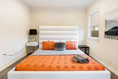 a bedroom with a large bed with an orange blanket at Comfy Home Near Sofi Stadium 2 in Los Angeles